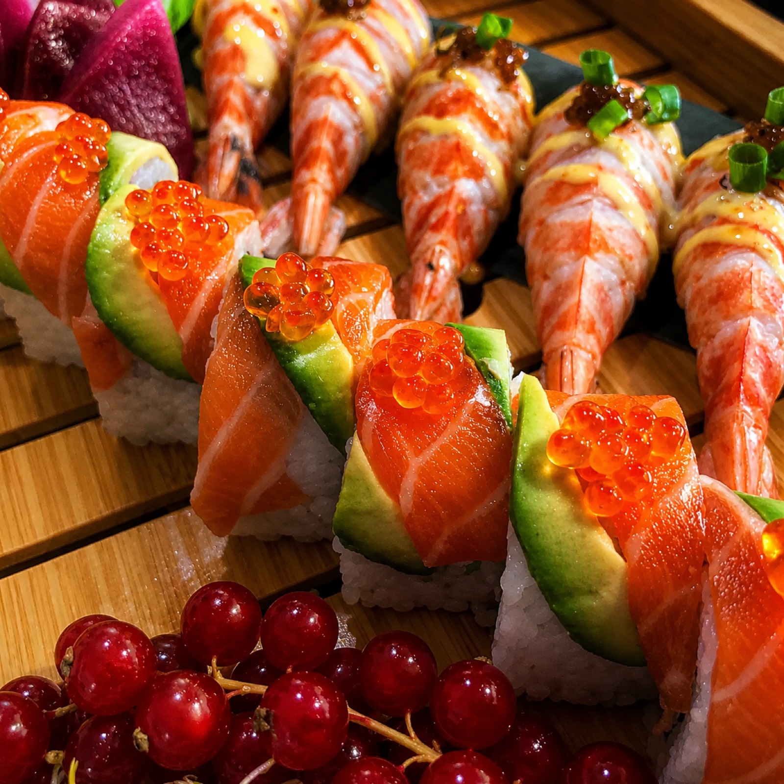 Detalle de nigiri de salmón con hueva y langostinos, recién preparados para un evento