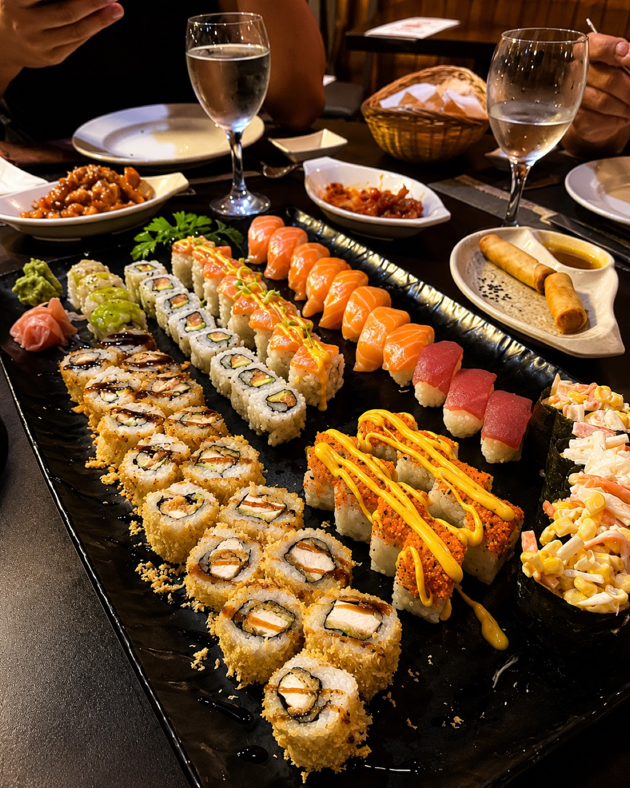 Plato circular variado de sushi con salmón, atún y makis, listo para compartir